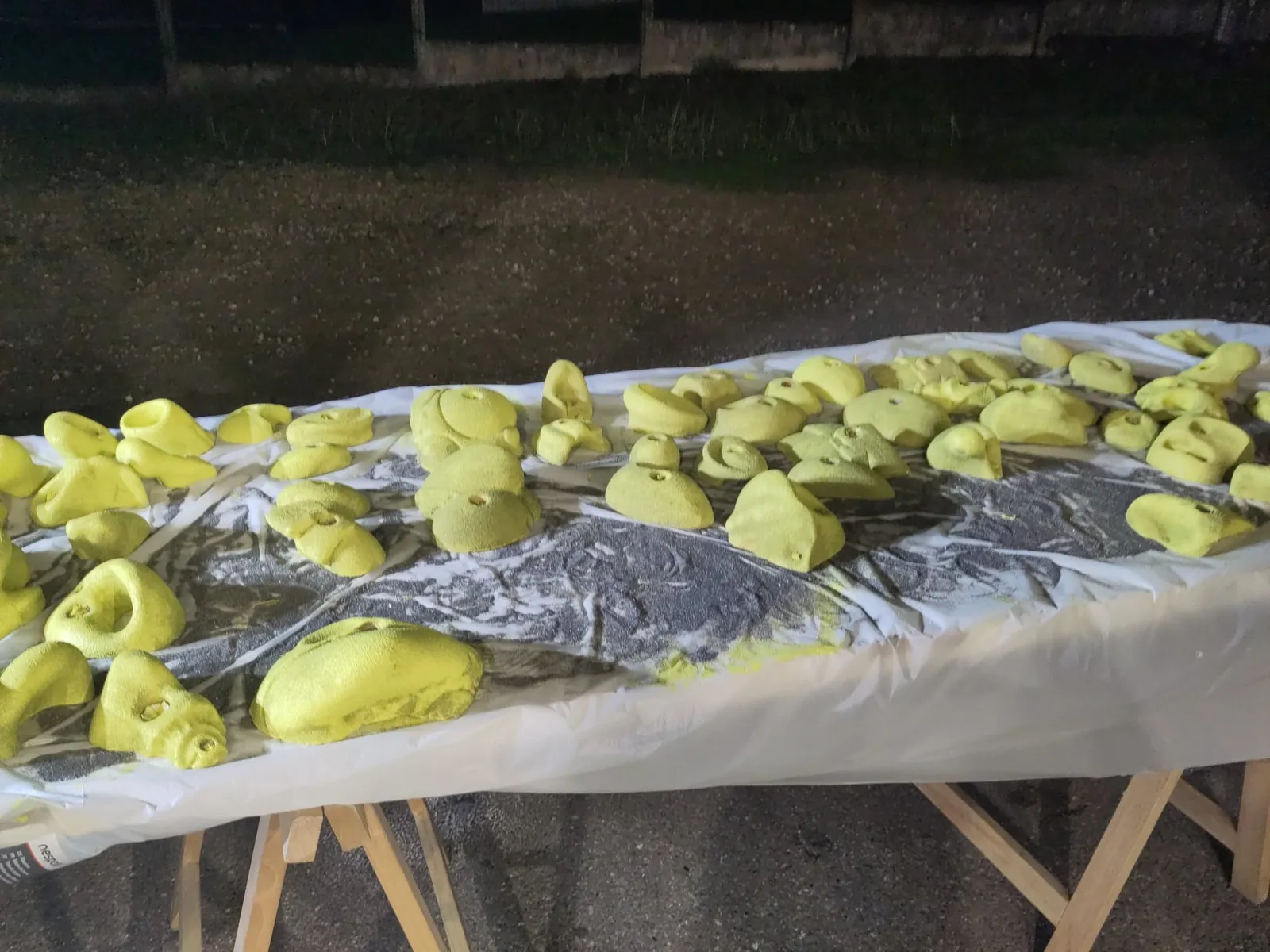 Une série de prises d’escalade jaunes fraîchement rénovées, en attente de séchage.